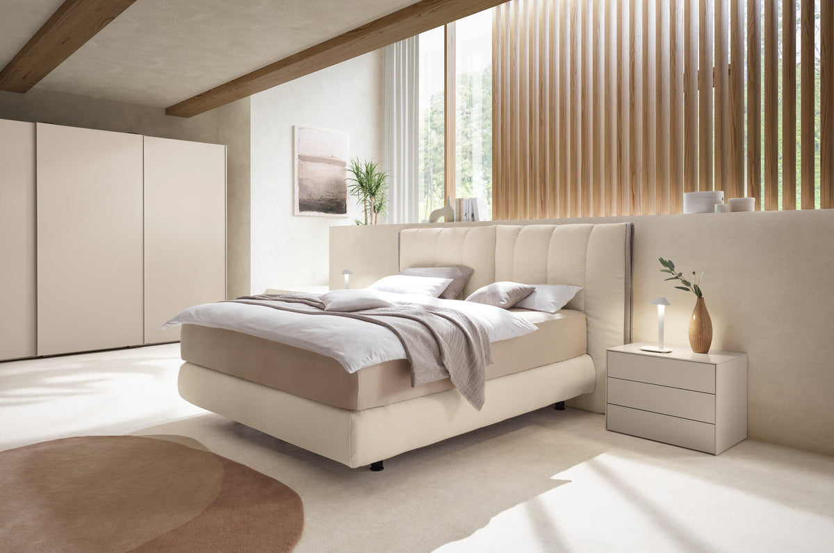 Schlafzimmer mit Bett und Stauraumlösung von Mette